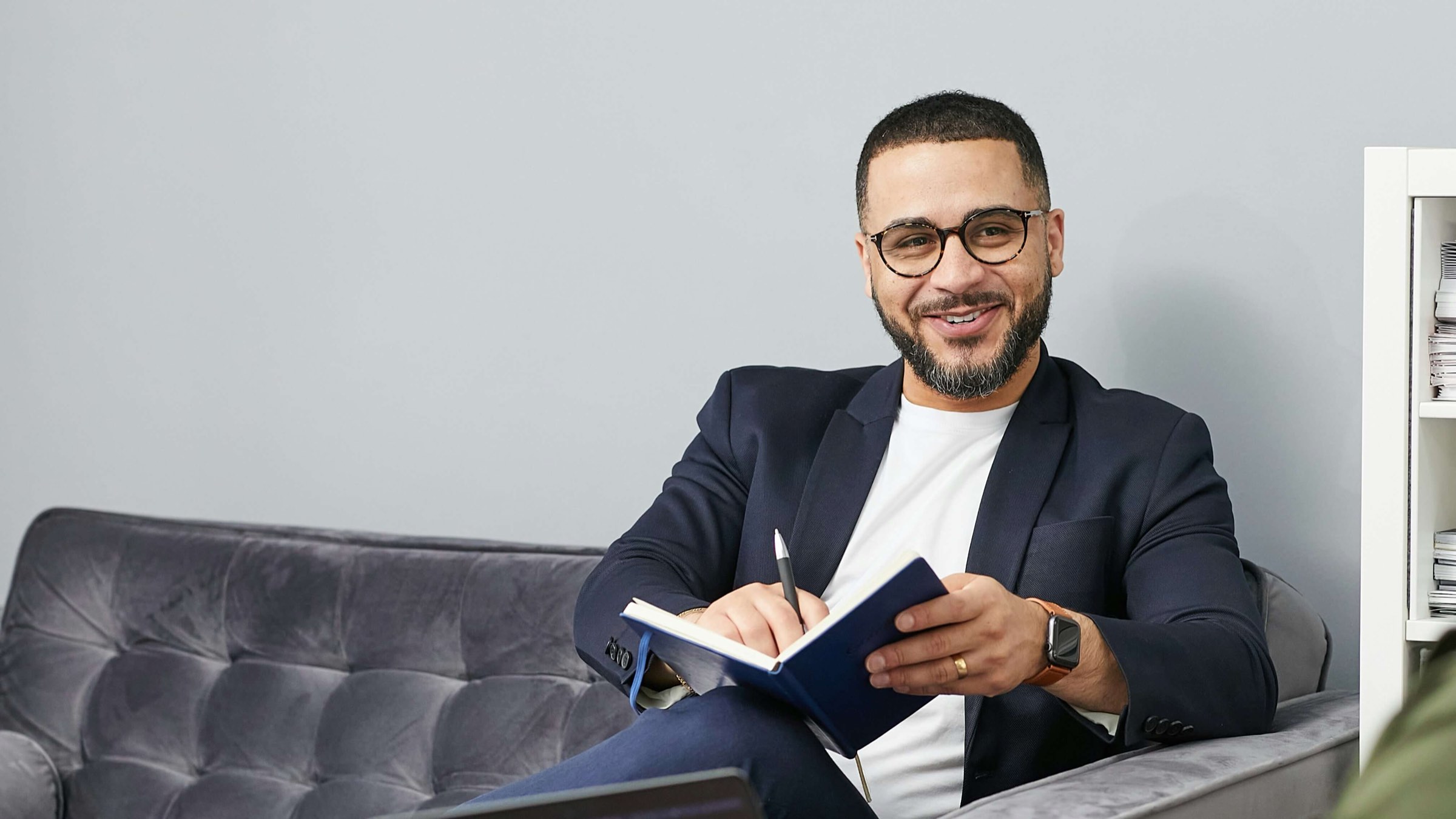 A clinician smiling while taking notes